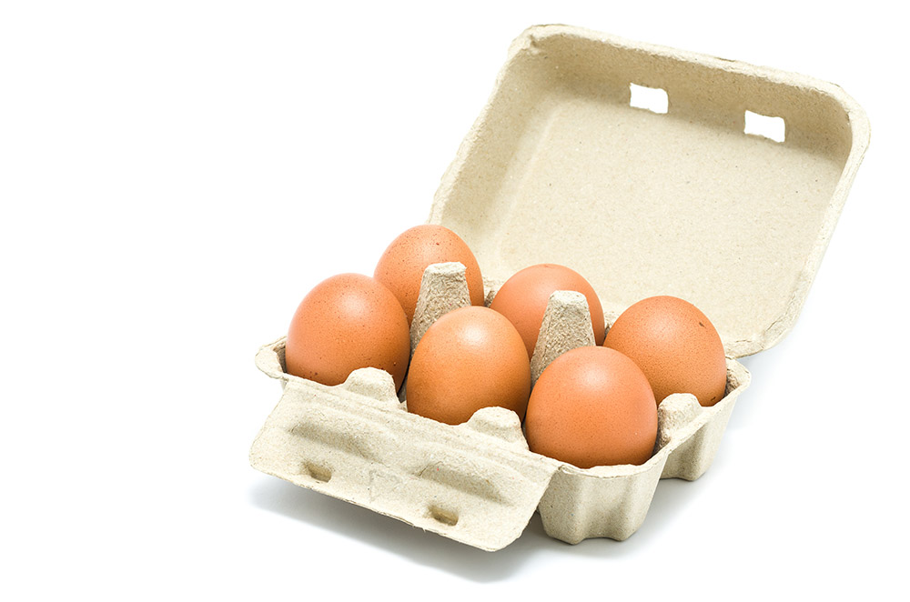 Eggs in a grey paper box on white background